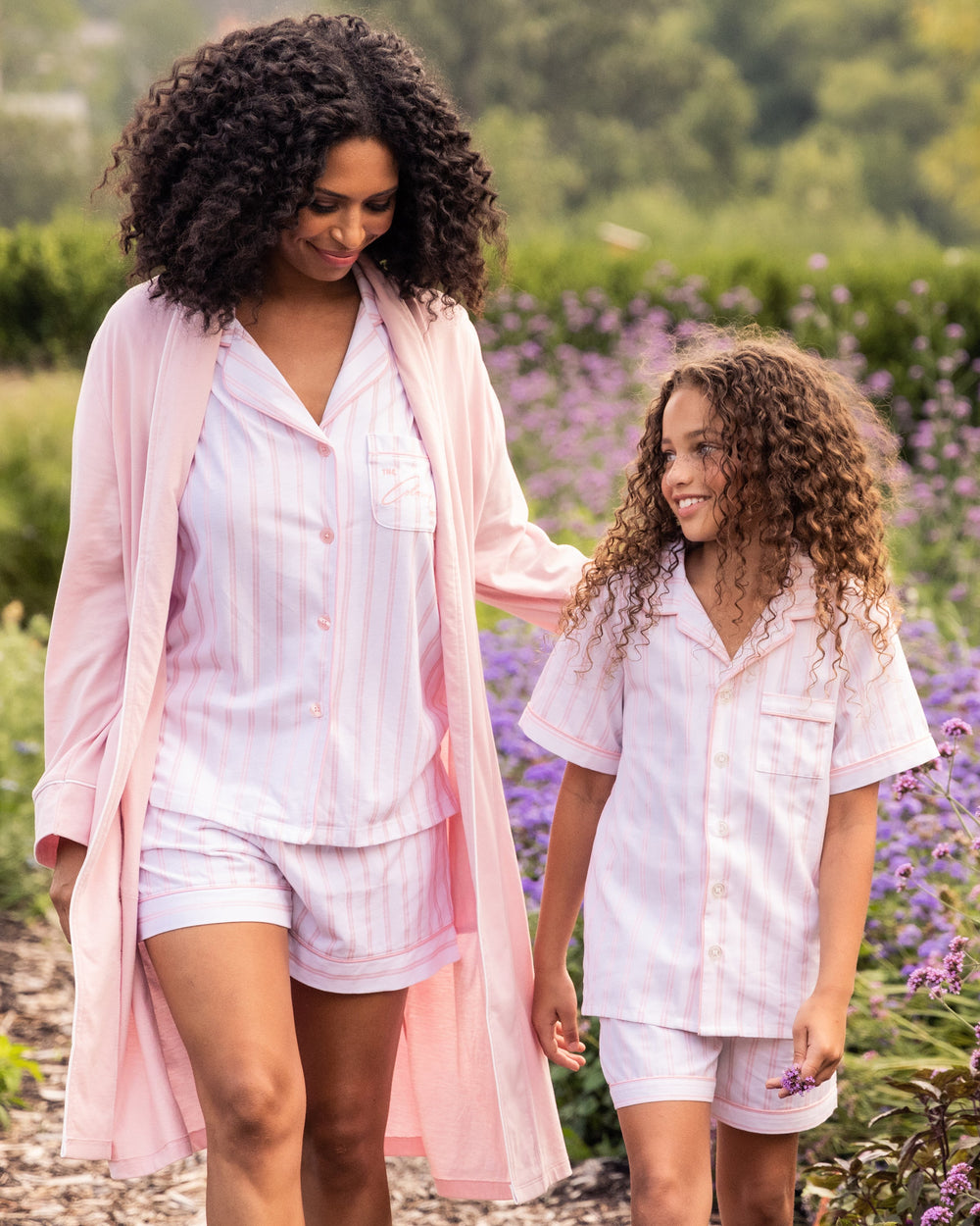 Woman and young girl in matching outfits walking through a lavender field
