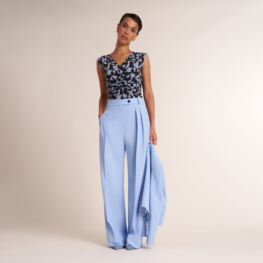 Woman wearing a navy and light blue printed top with light blue pants