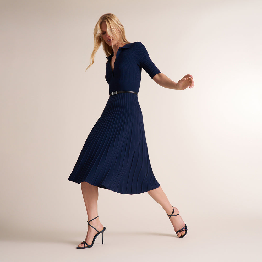 Woman wearing a three quarter sleeve dress with a midi pleated skirt
