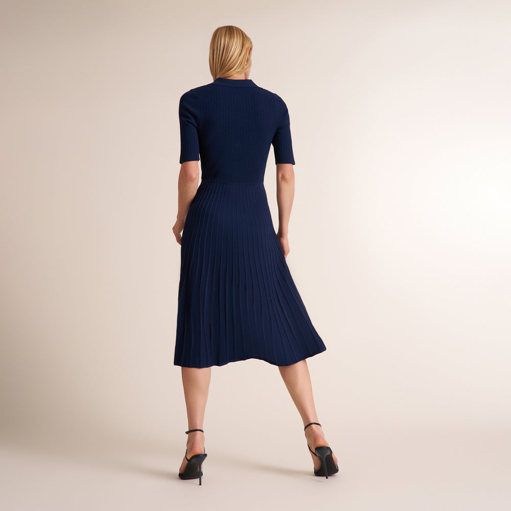 Woman wearing a three quarter sleeve dress with a midi pleated skirt