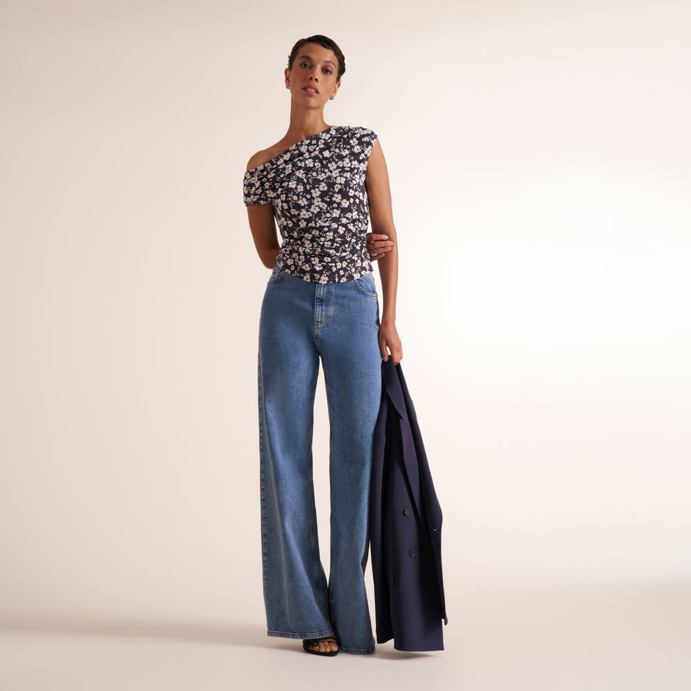Woman wearing a floral off the shoulder top and jeans