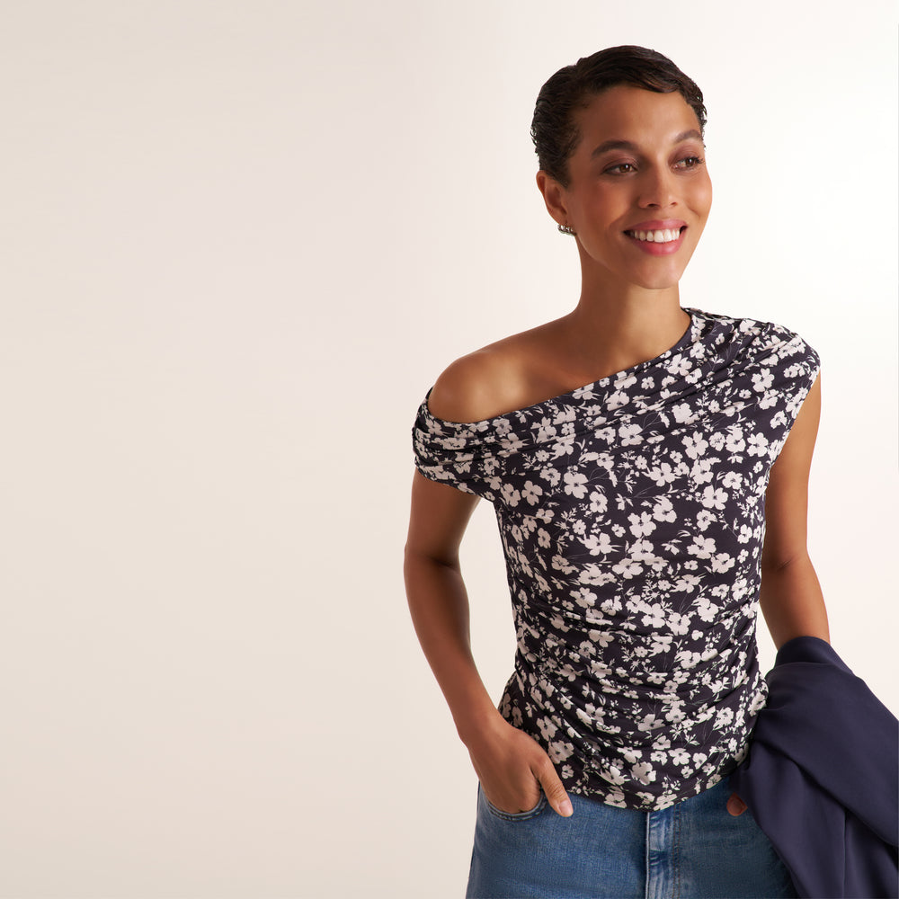 Woman wearing a floral off the shoulder top and jeans