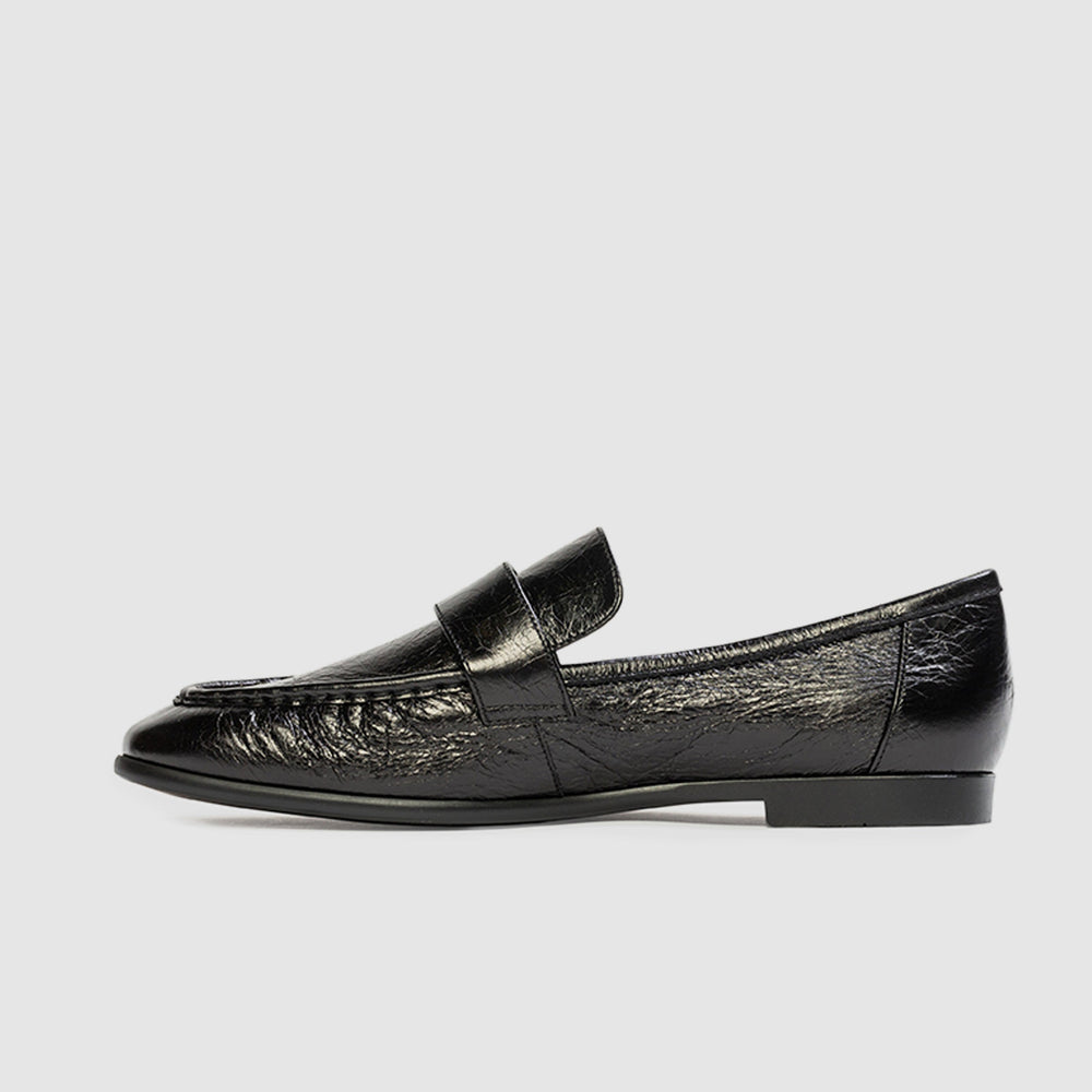 Black loafer shoe on a light gray background