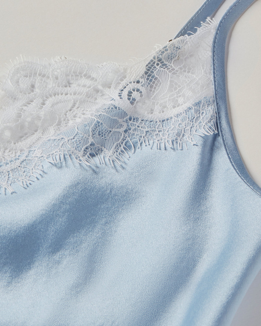 Light blue sleeveless top with lace detailing on a neutral background