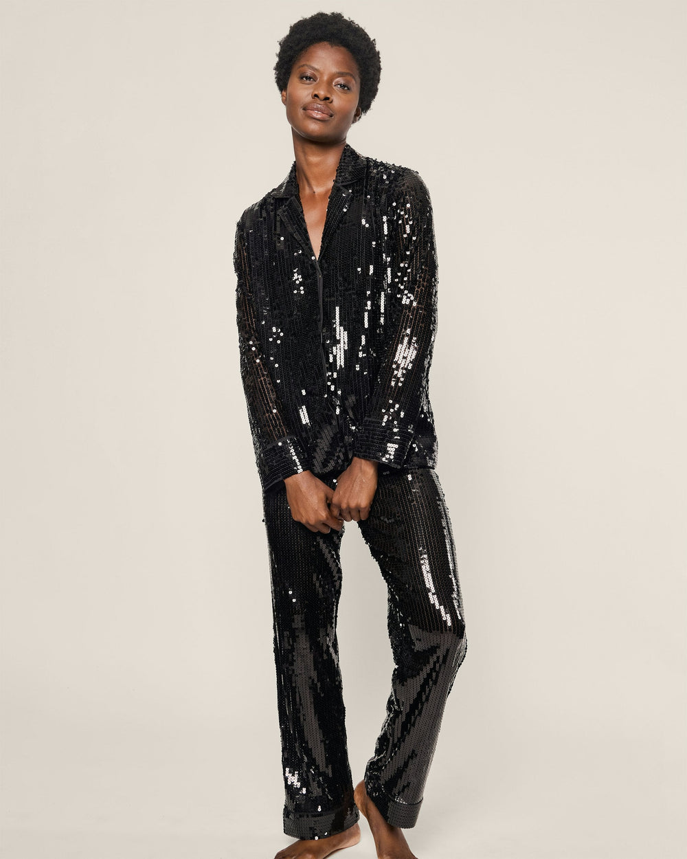 Person wearing a black sequin suit on a plain background