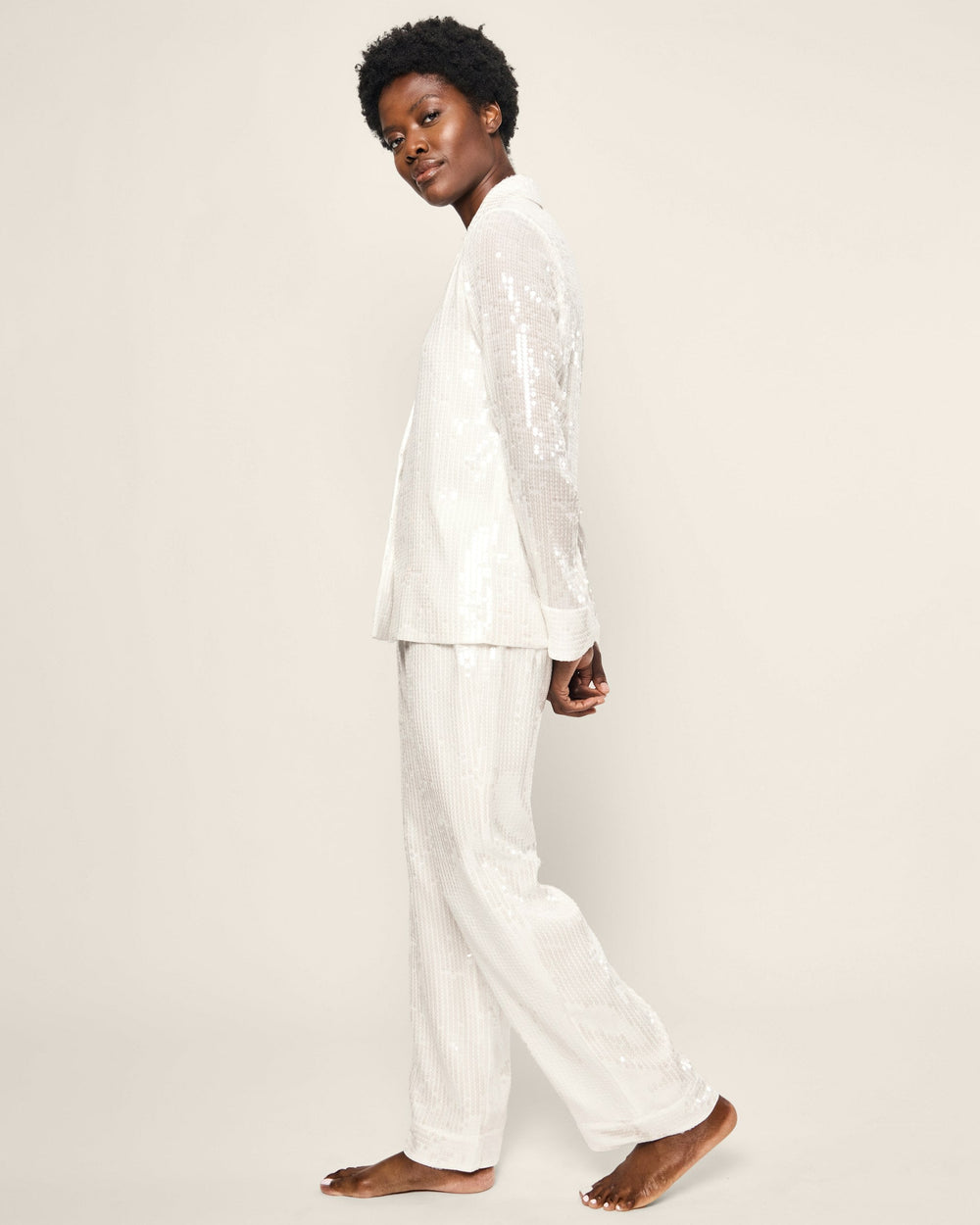 Person wearing a white pajama set on a plain background