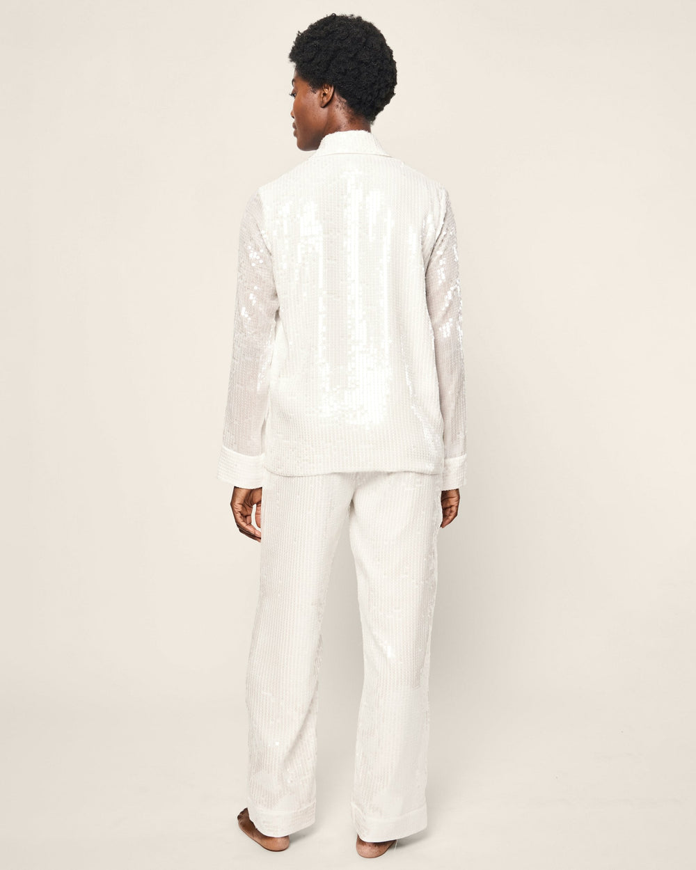 Person wearing a white outfit on a plain background