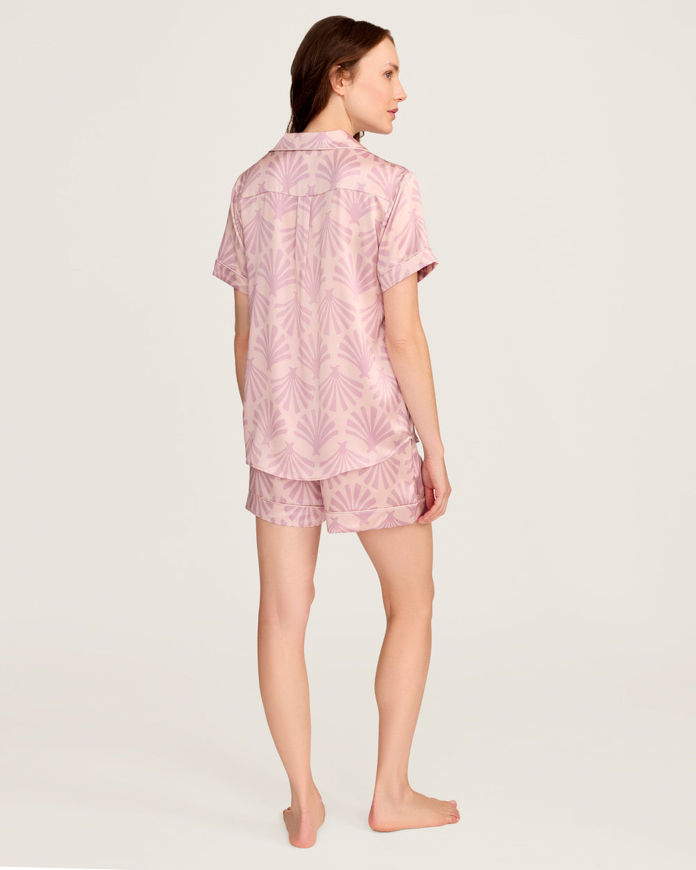 Woman wearing a pink pajama set with a white background