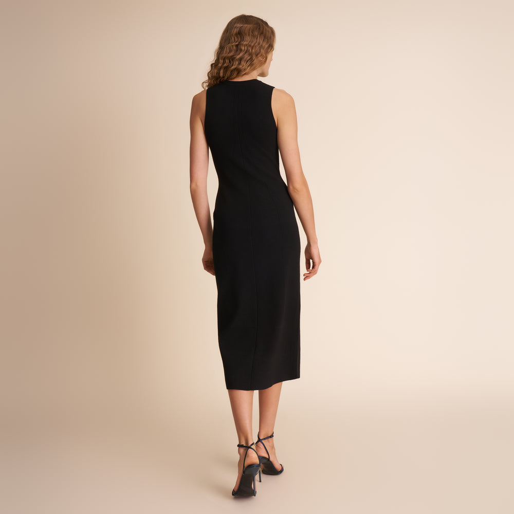 Woman wearing a black sleeveless dress against a beige background
