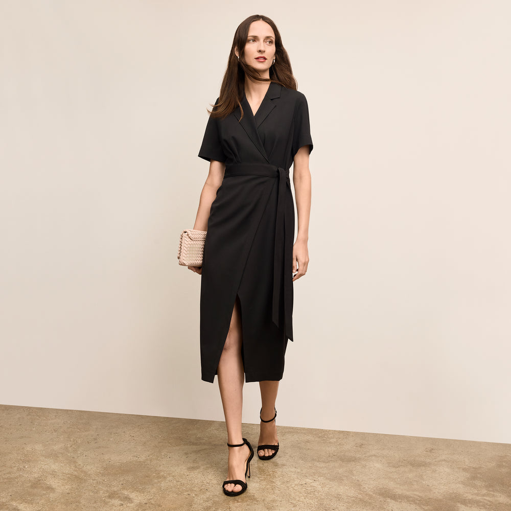 Woman wearing a black dress with a beige background