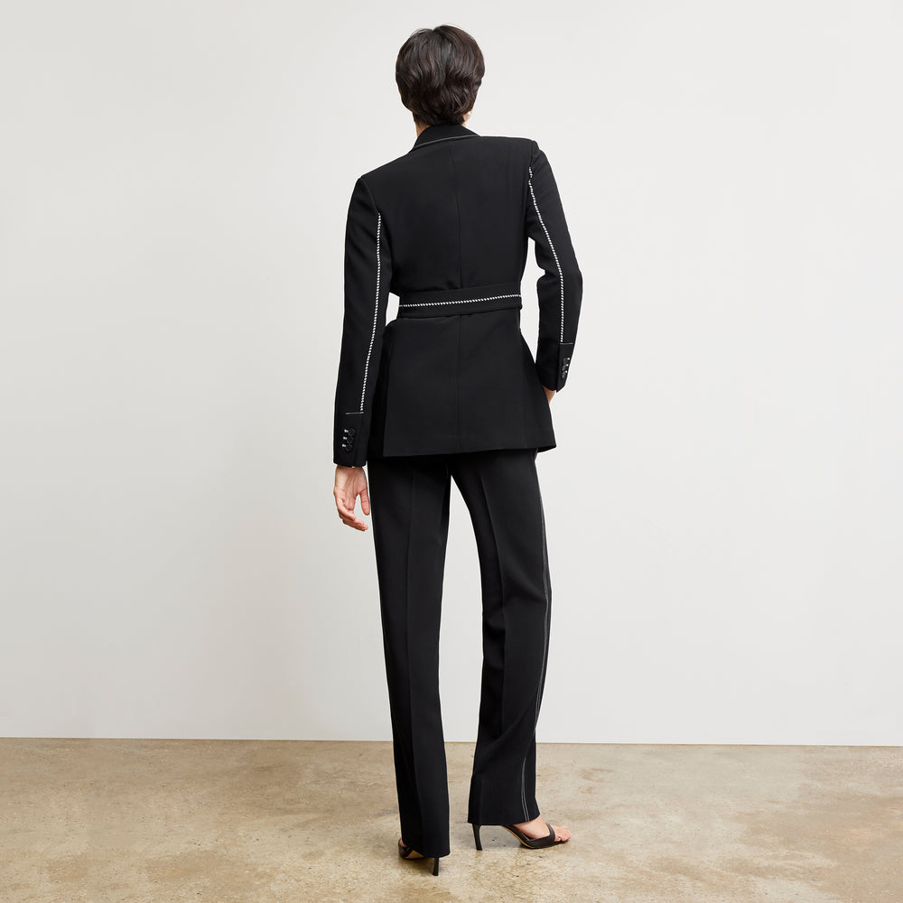 back image of a woman wearing the athena blazer in black with topstitch