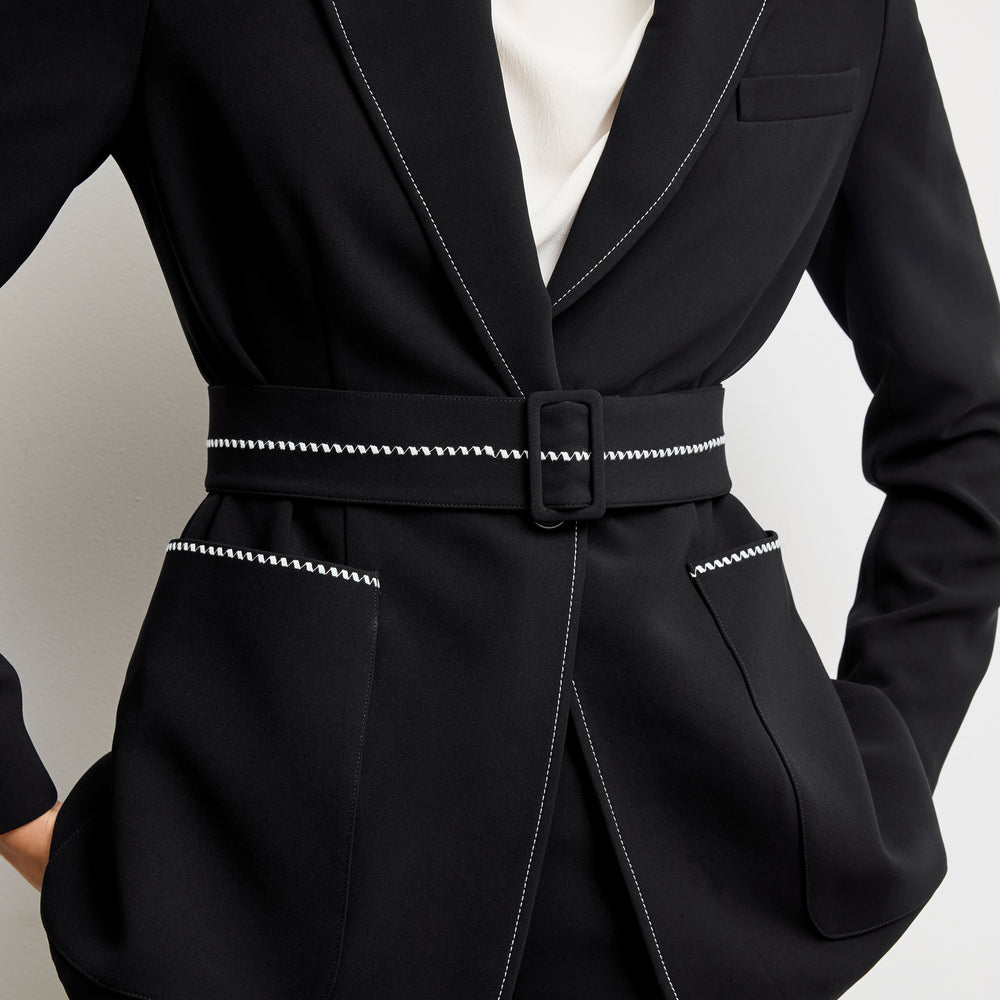 detail image of a woman wearing the athena blazer in black with topstitch