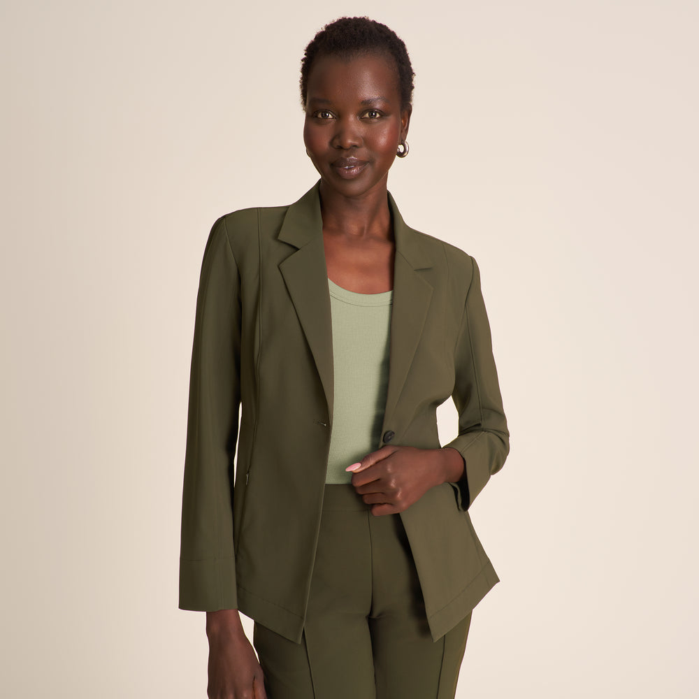 Woman wearing a brown suit against a beige background