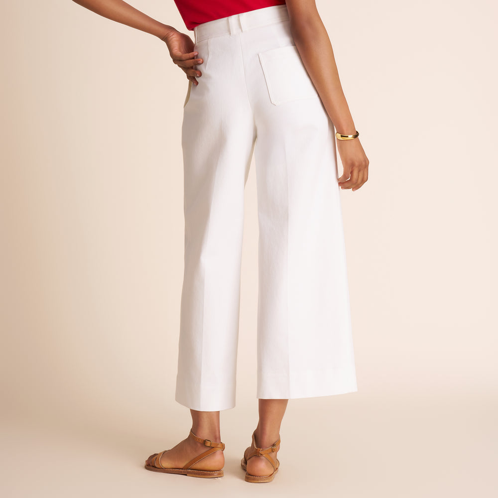 Person wearing white pants on a beige background