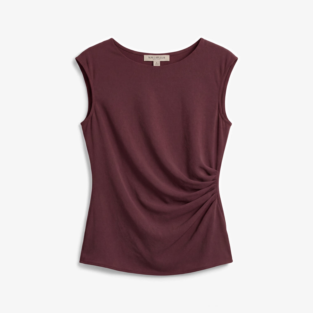 A sleeveless crewneck top in a deep burgundy color, featuring a draped side detail, shown flat against a light gray background.