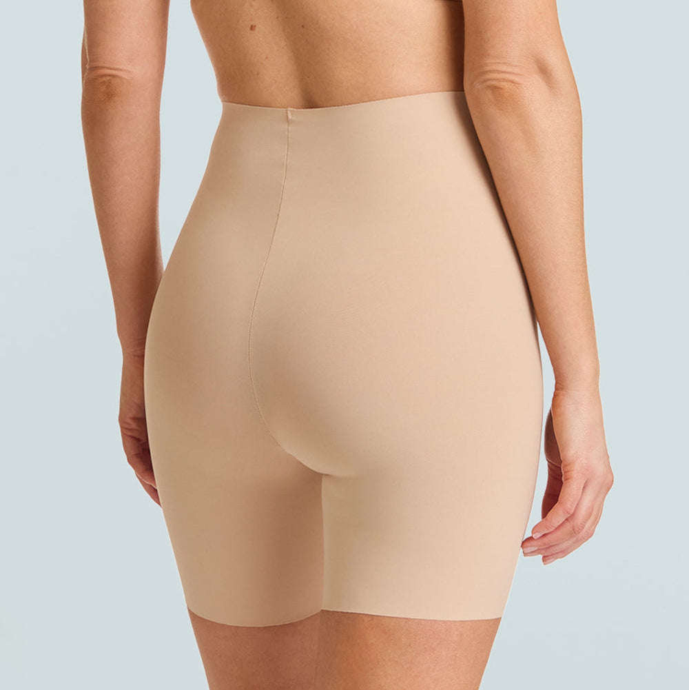Beige shapewear shorts worn by a person on a light gray background