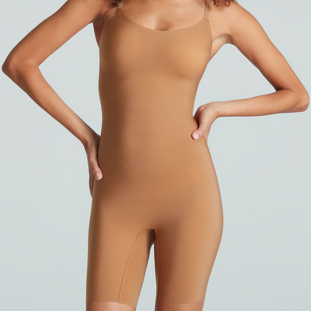 Person wearing a brown bodysuit against a light gray background