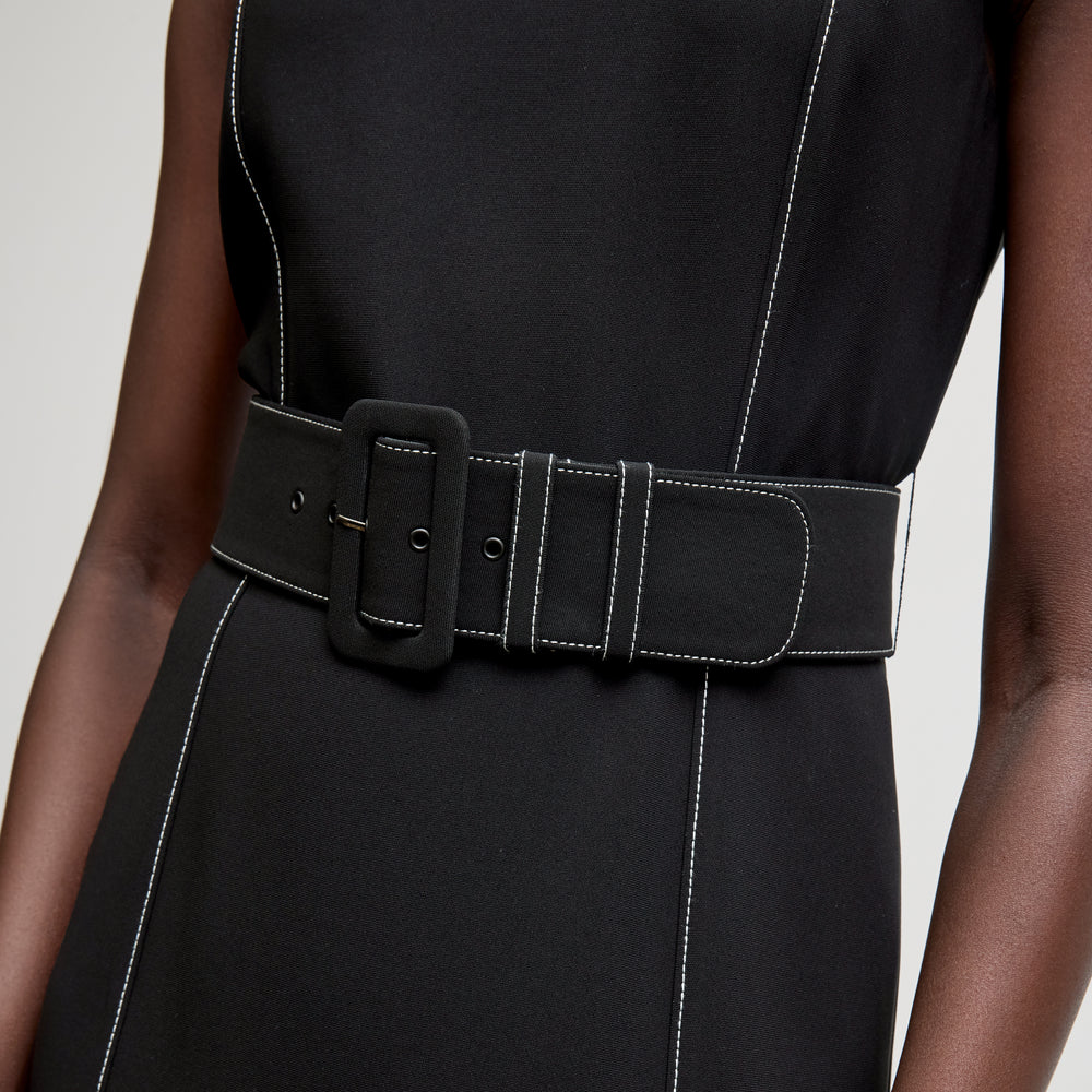 front image of a woman wearing the carmela dress in black with topstitch