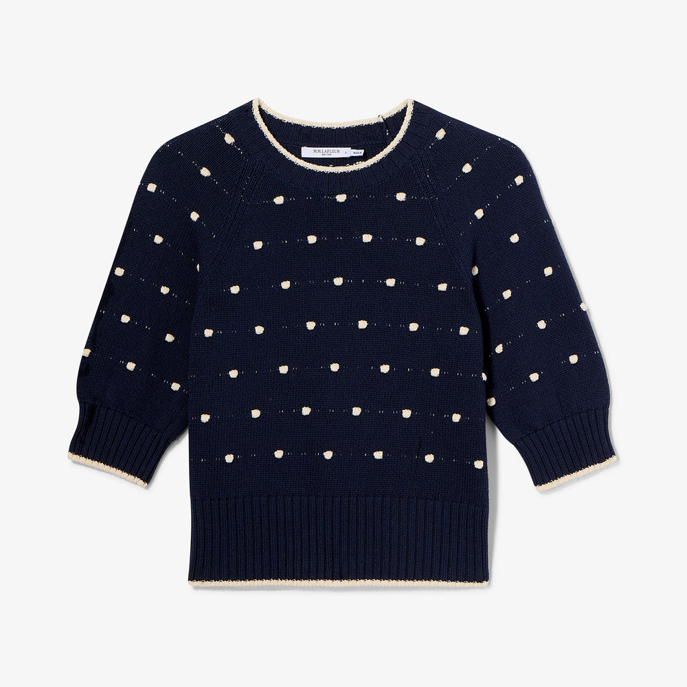 Navy sweater with white dot pattern on a light gray background