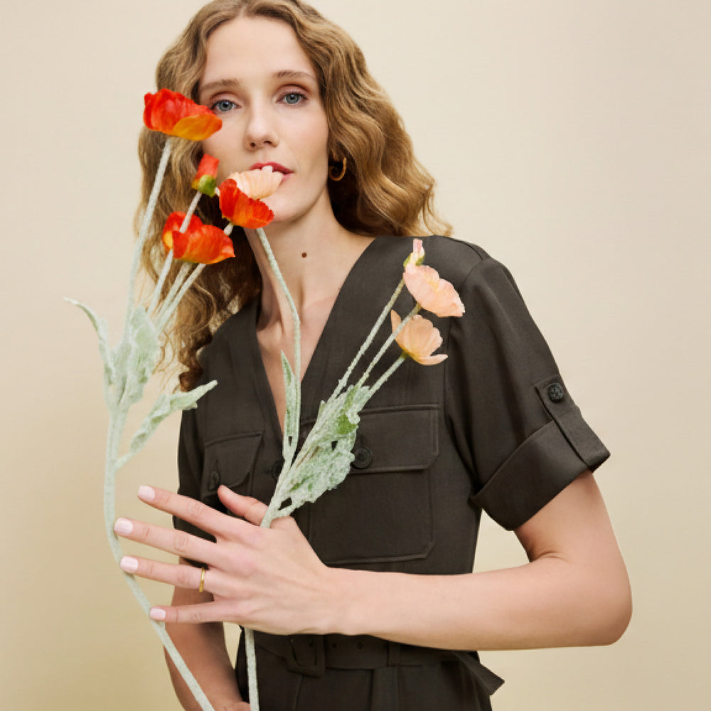 Woman holding flowers against a beige background