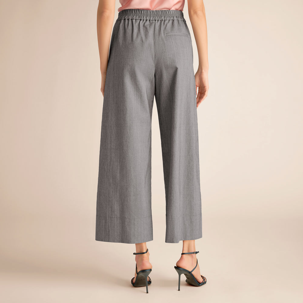 Gray wide-leg pants worn by a person on a beige background