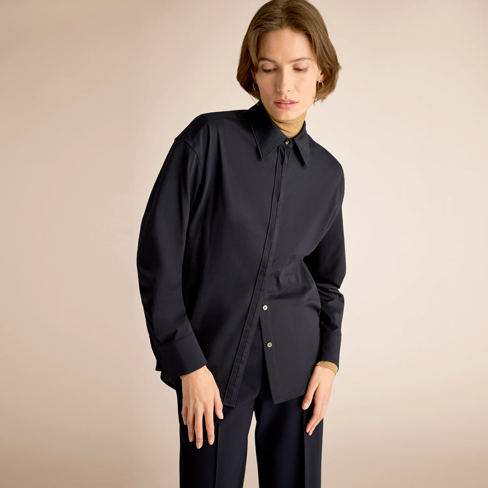 Person wearing a black shirt and pants on a beige background