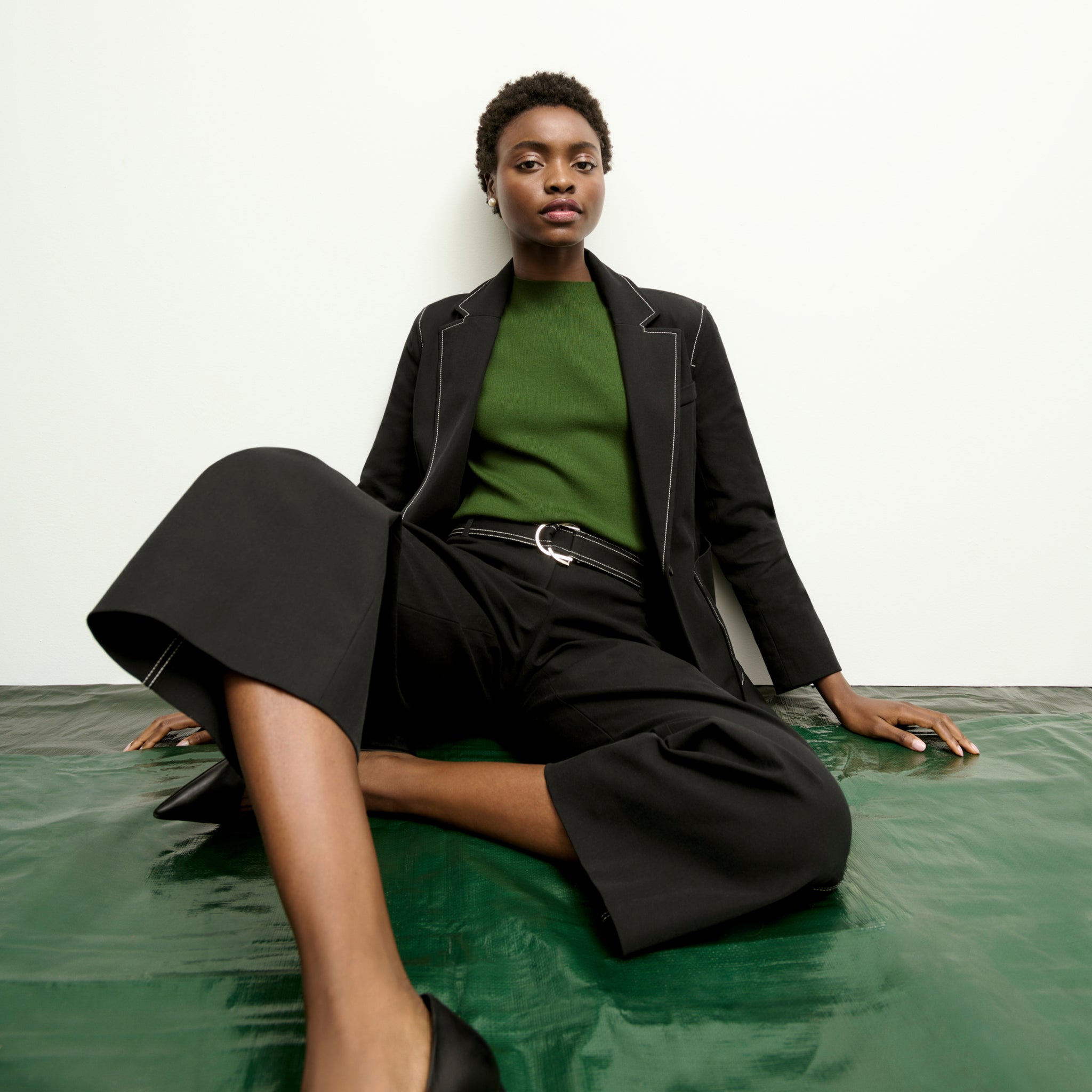 mood image of a woman sitting wearing the grenville jacket in black