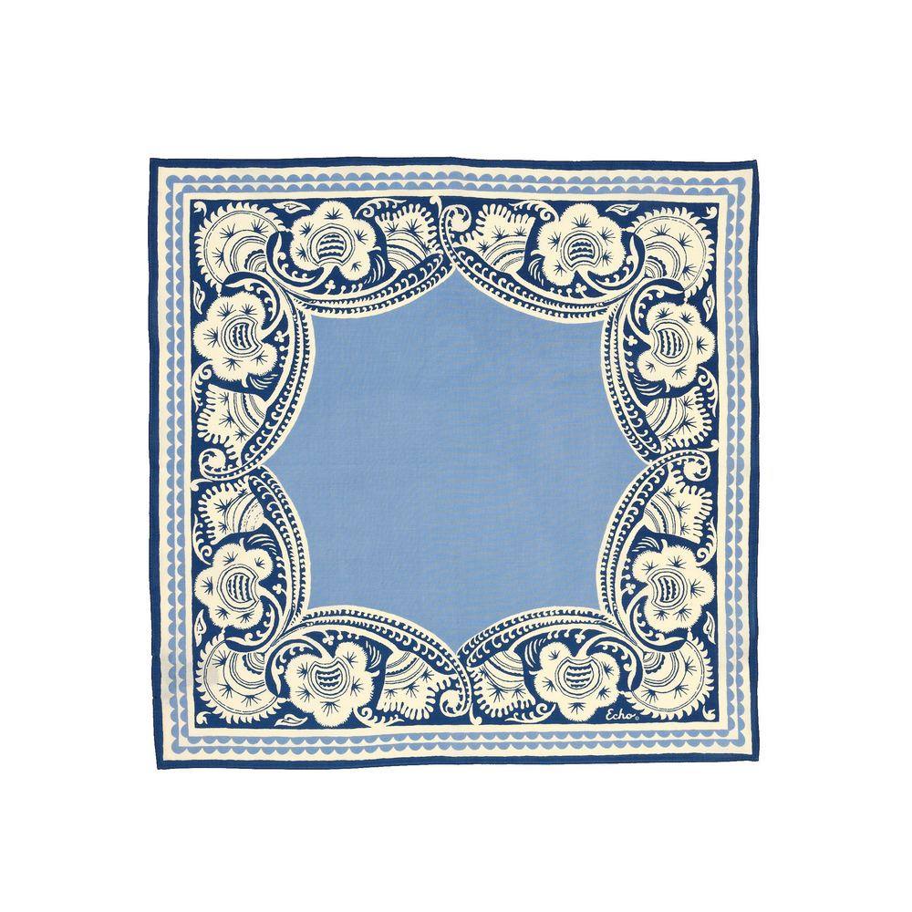 A square bandana featuring a light blue center surrounded by an ornate navy blue and cream floral border pattern, shown flat against a white background.