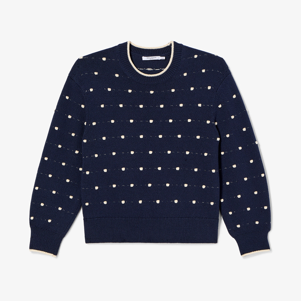 Navy sweater with white dot pattern on a light blue background