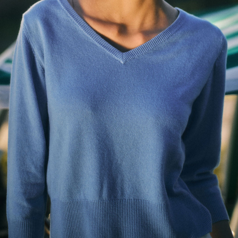 Person wearing a blue sweater with a blurred background