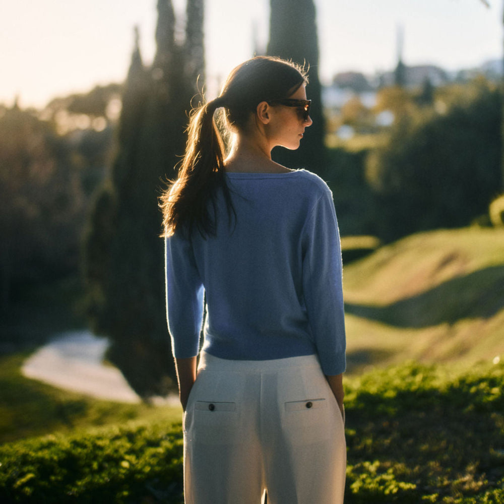 Woman standing in a park with trees and a clear sky