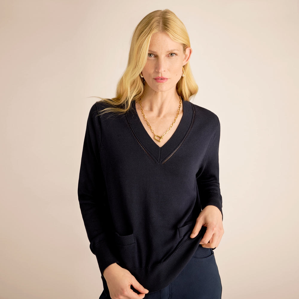 Woman wearing a black sweater against a beige background