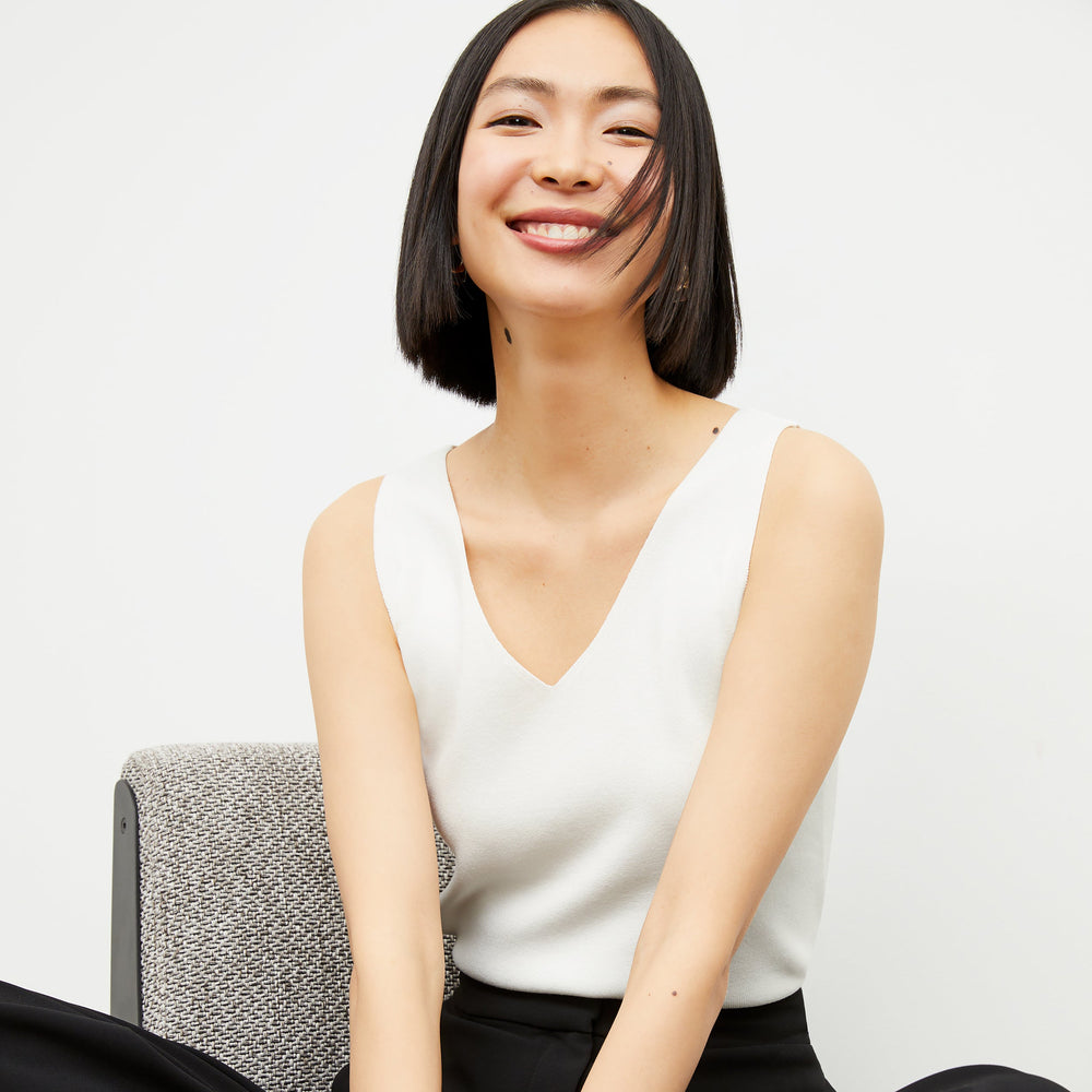 Front image of a woman standing wearing the Peggy top in ivory