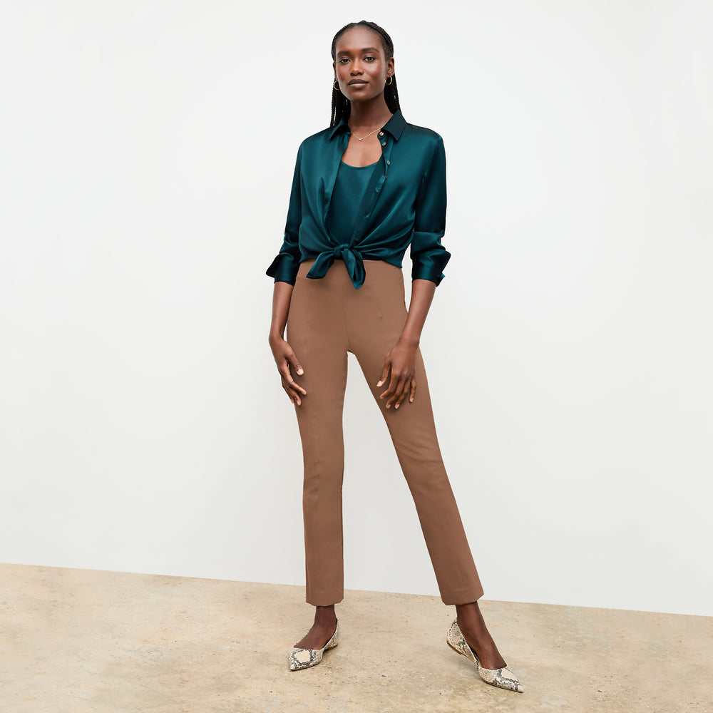 Front image of a woman sitting wearing the Foster Pant—Everstretch in Saddle