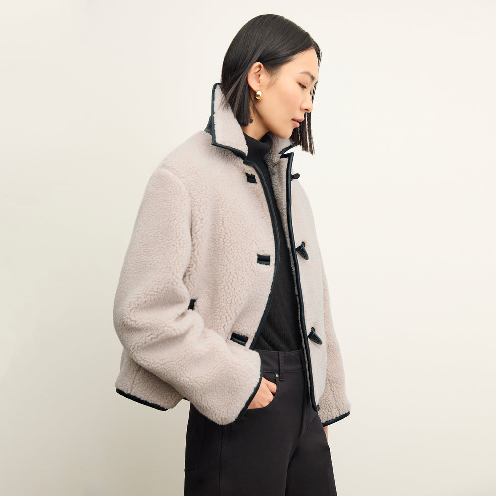 side image of a woman wearing the eli jacket in travertine