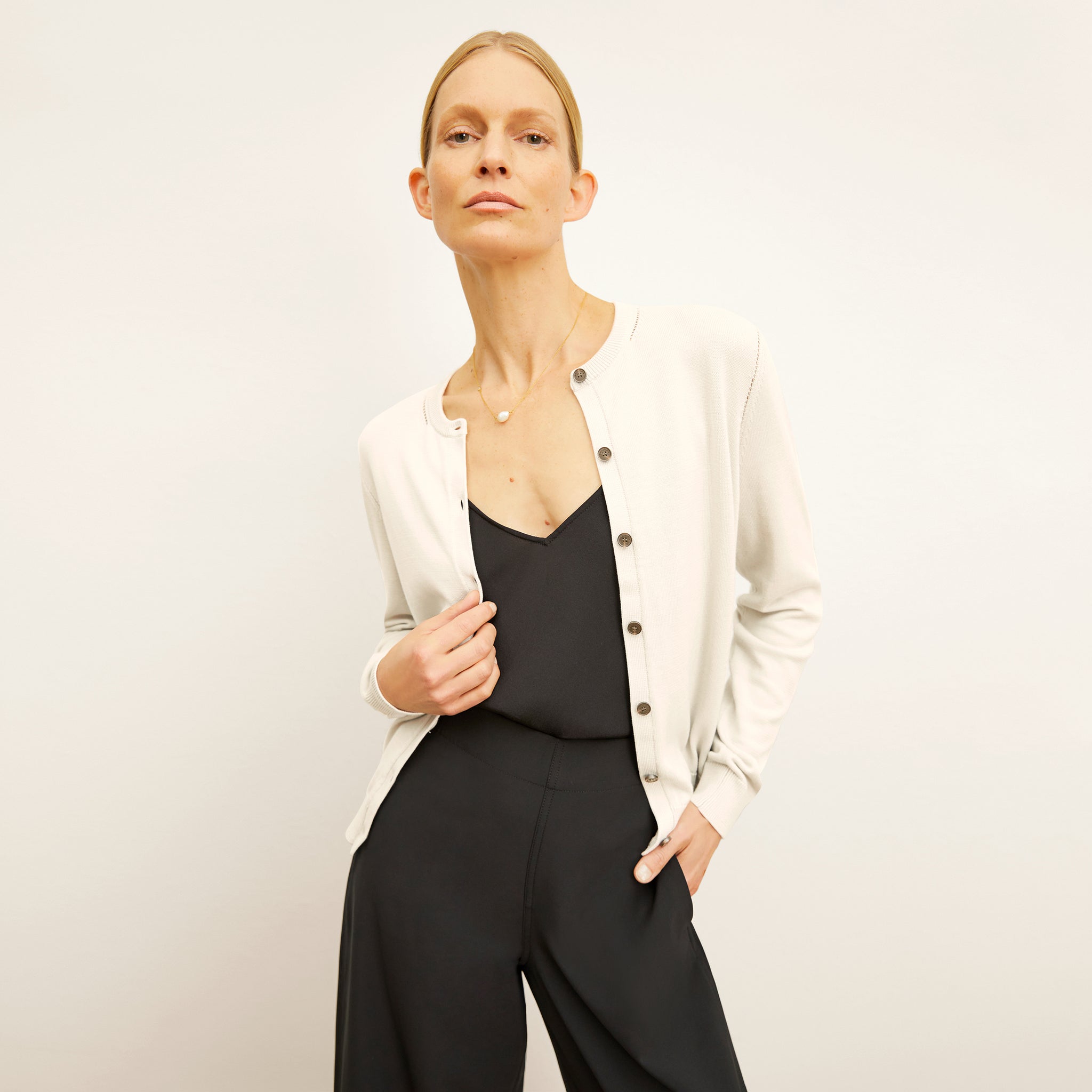 front image of a woman wearing the mel cardigan in ivory 