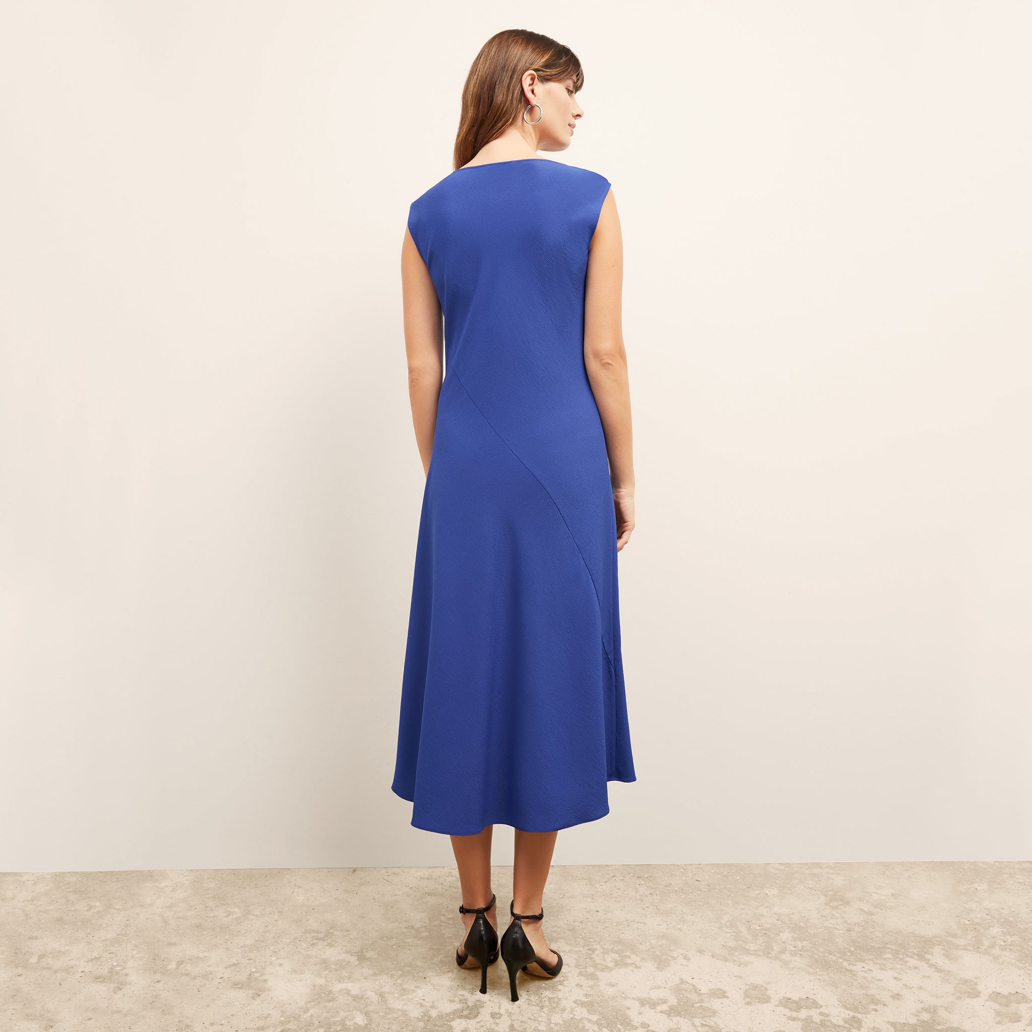 back image of a woman wearing the priya dress in electric blue