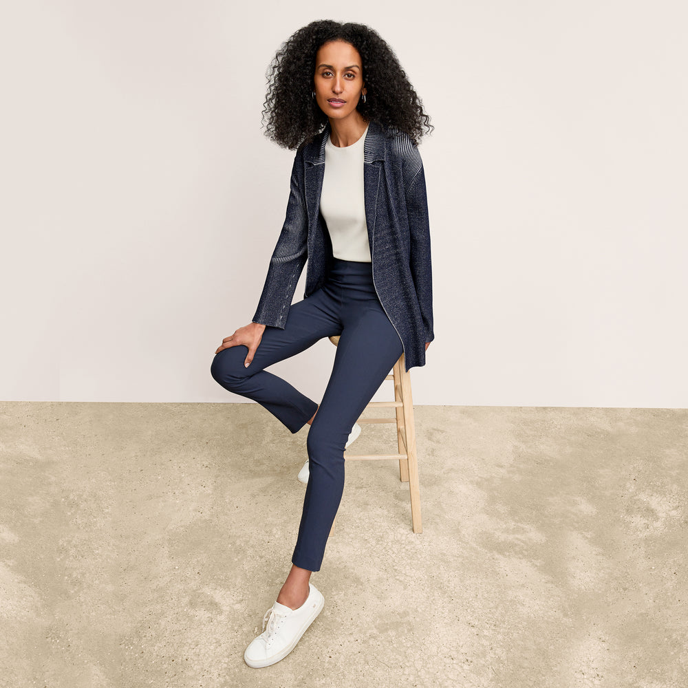 Front image of a woman standing wearing the foster pant in dark navy