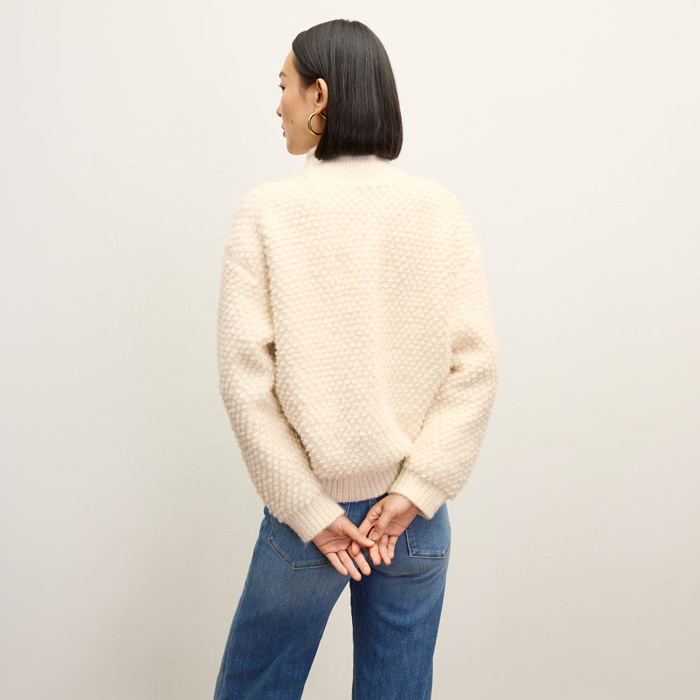 back image of a woman wearing the lea sweater in snow