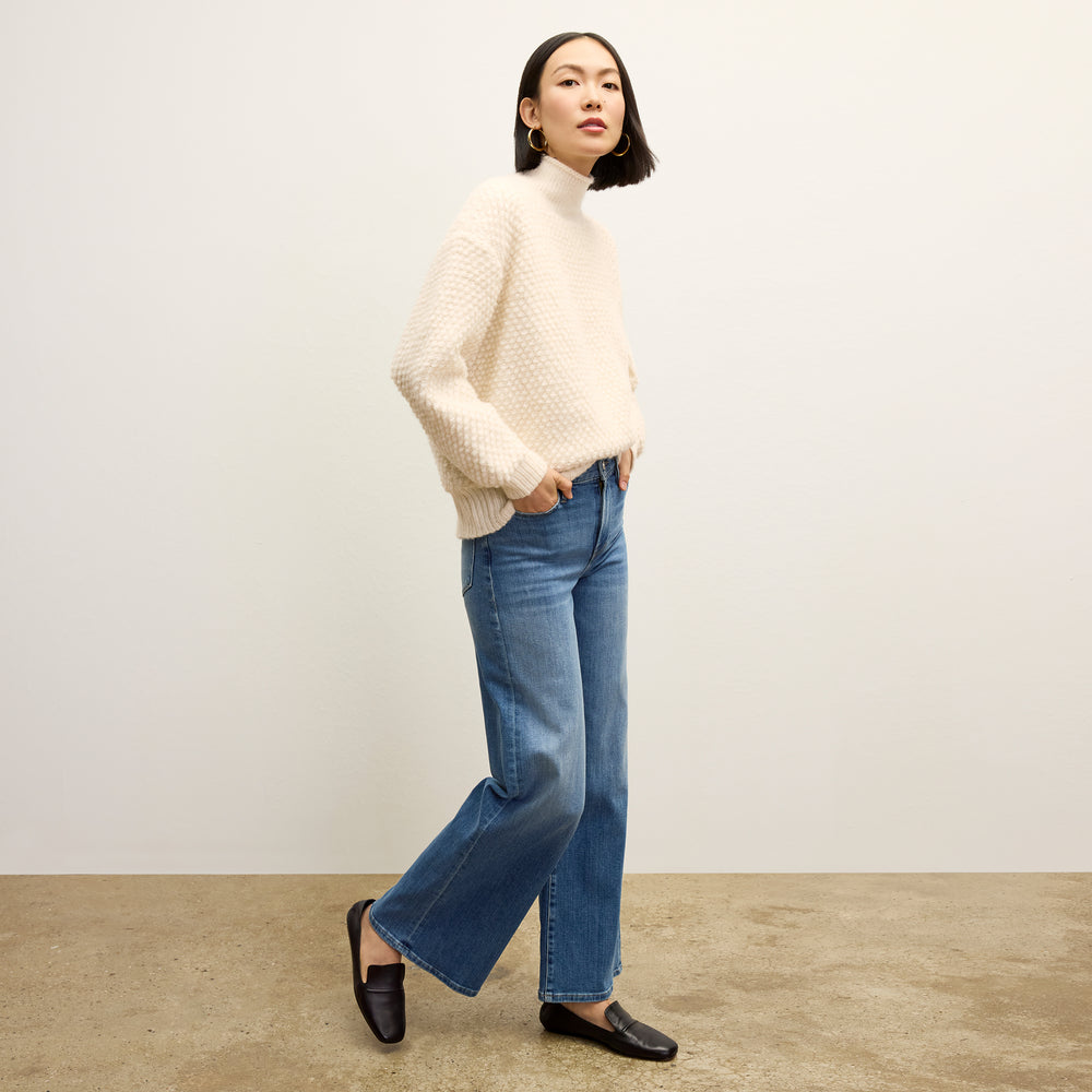 front image of a woman wearing the lea sweater in snow
