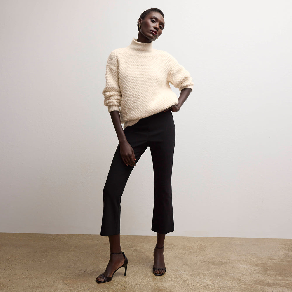 front image of a woman wearing the lea sweater in snow