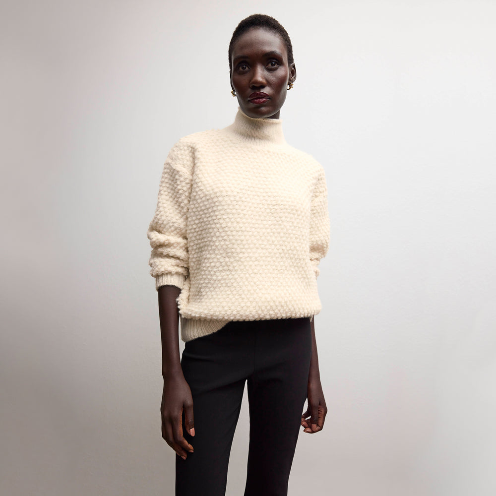 front image of a woman wearing the lea sweater in snow