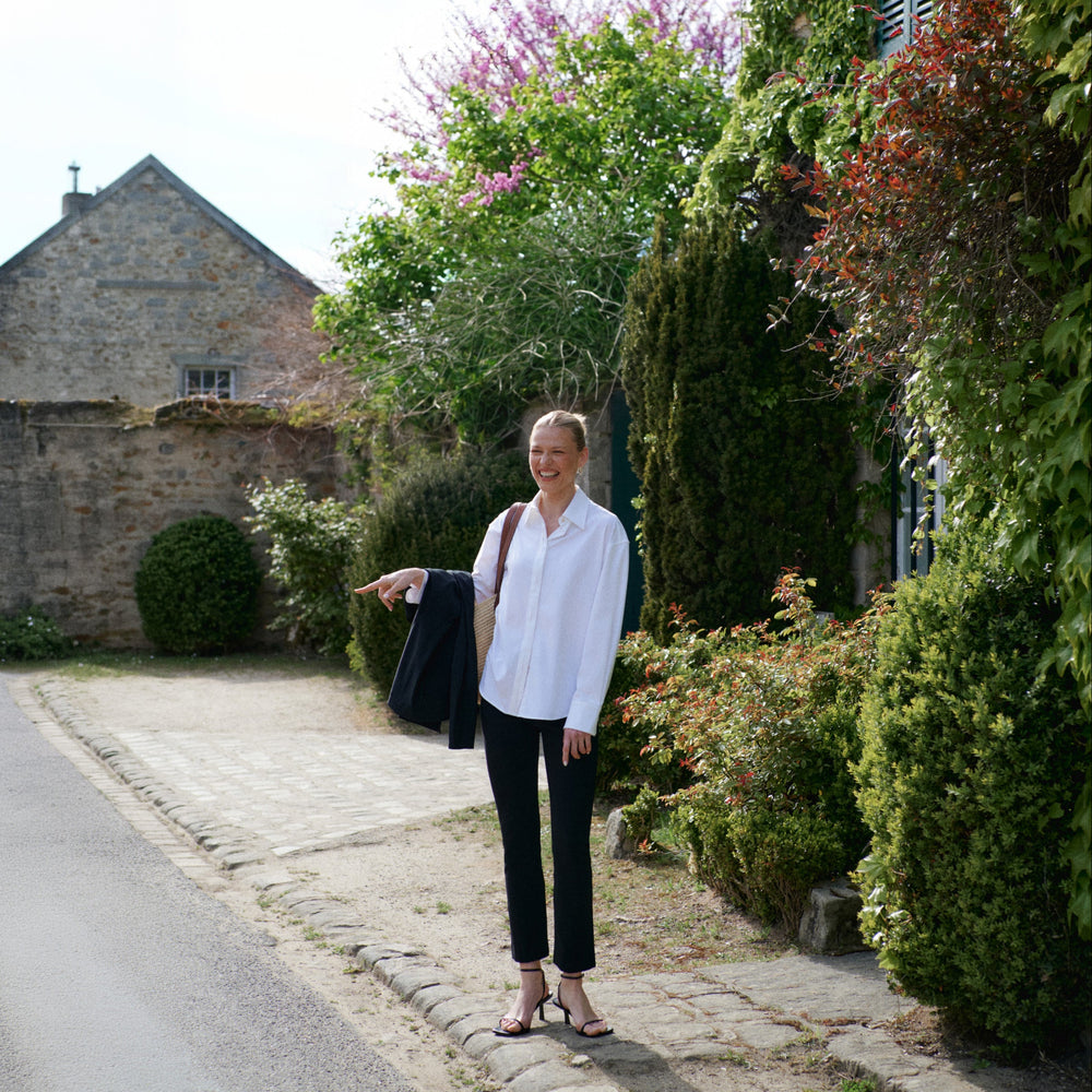 Person wearing black pants and a patterned top on a country road