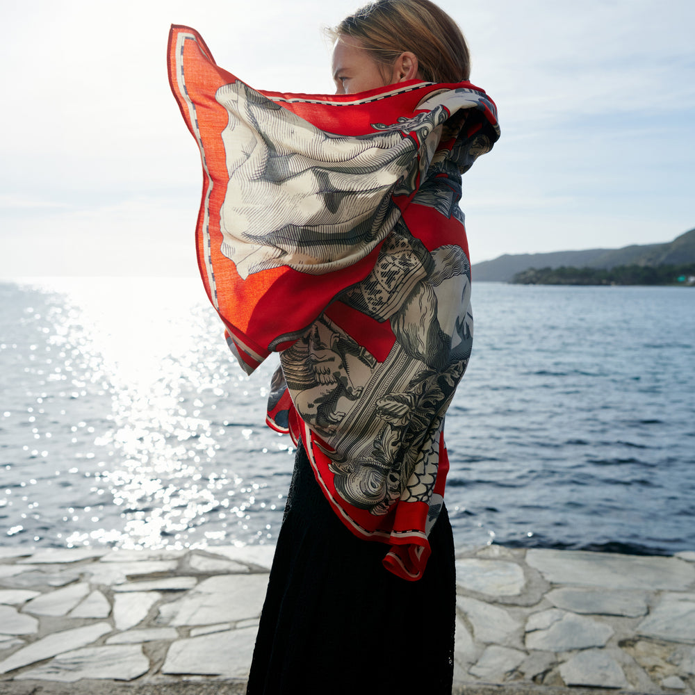 Person wearing a large scarf with a scenic background