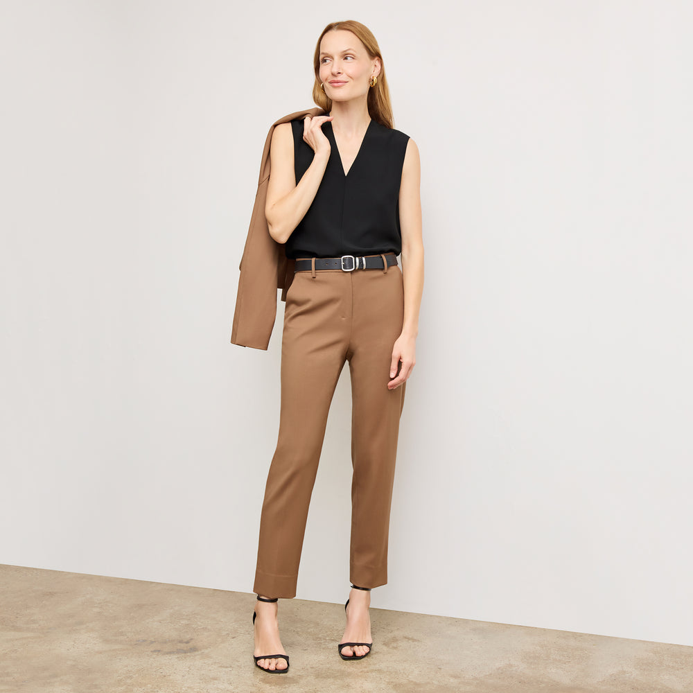 Front image of a woman standing wearing the Mejia pant in camel