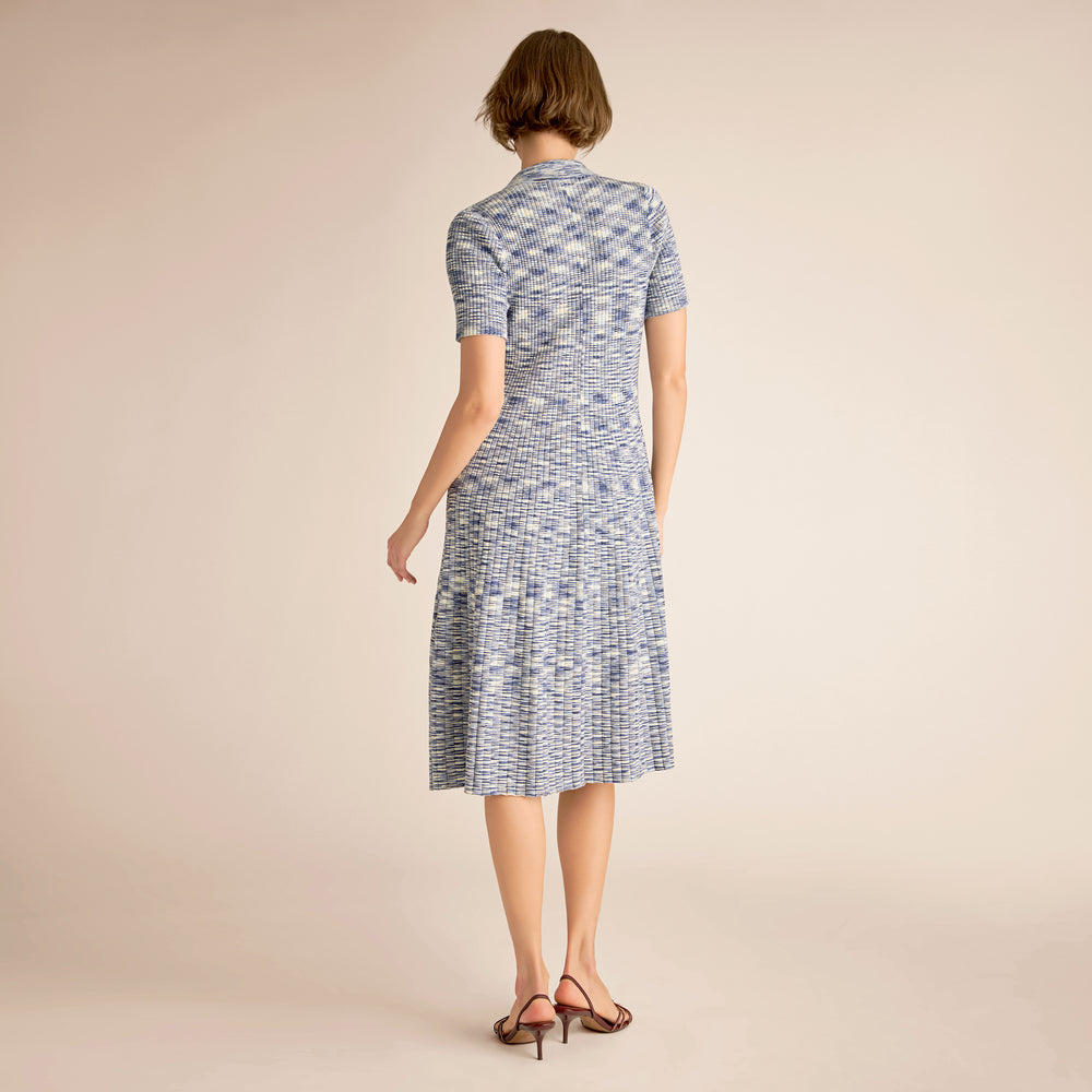 Woman wearing a blue patterned dress on a beige background