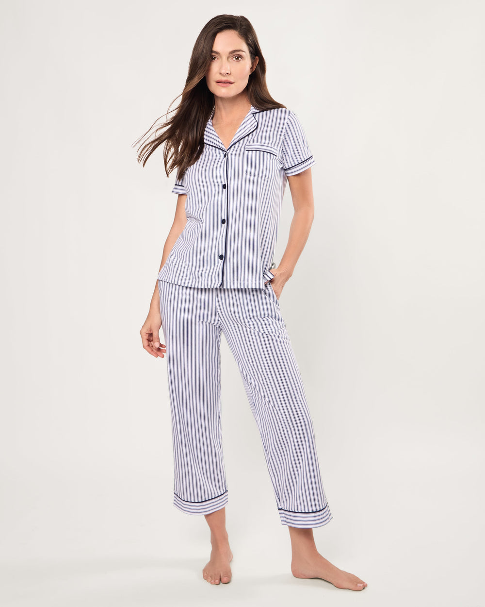 Woman wearing a blue and white striped pajama set on a white background