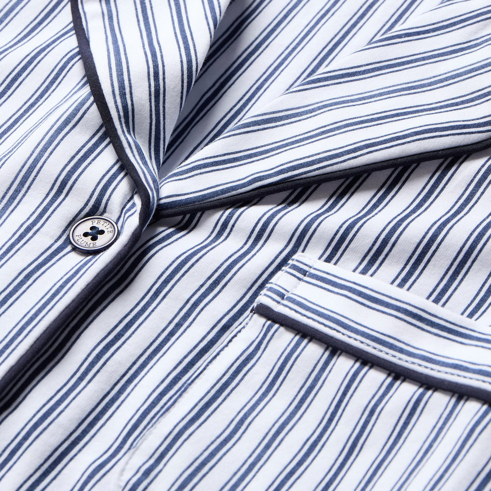 Close-up of a blue and white striped shirt with a button.