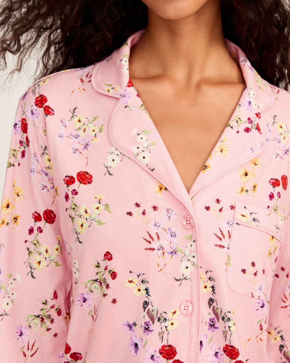 Close-up of a pink floral pajama top worn by a person