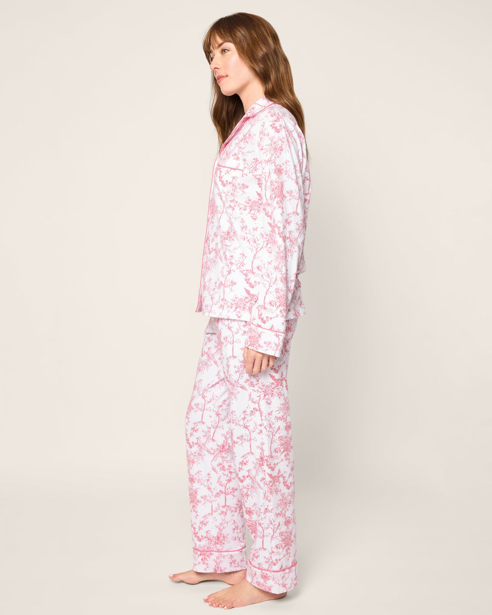 Woman wearing a pink floral pajama set on a white background
